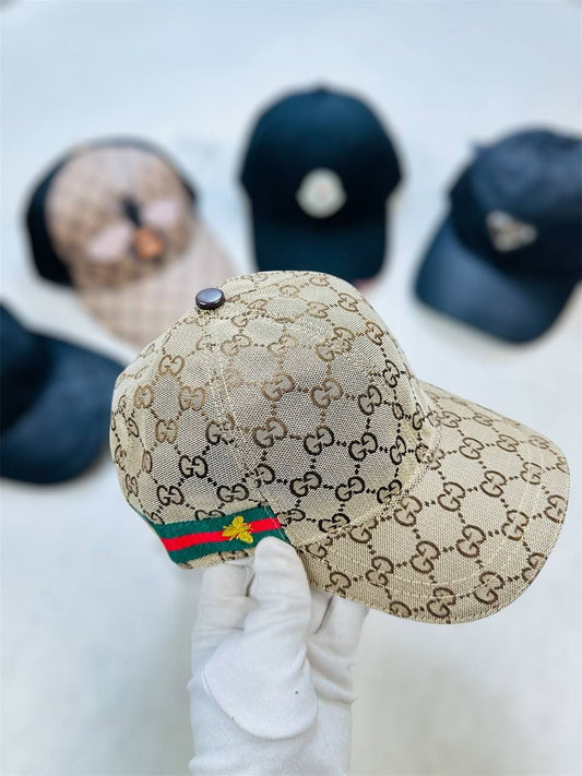 Beige cap with Gucci logo and flag design held by a gloved hand